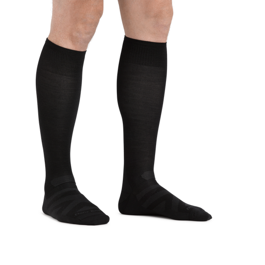 Man standing barefoot wearing RFL Over the Calf Ultralightweight Ski & Snowboard Sock in Black
