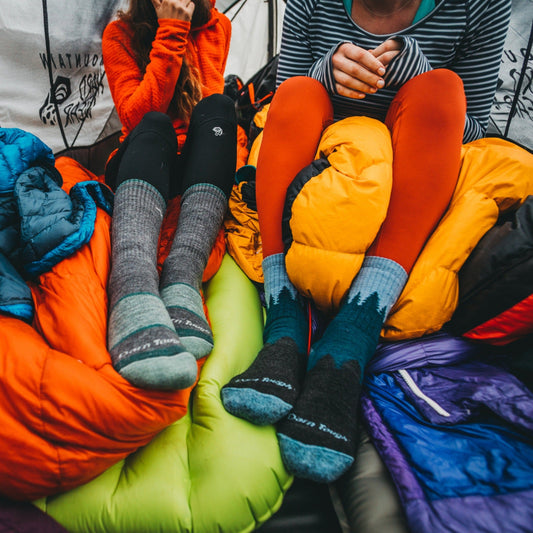 Women in a tent with their Darn Tough Socks on